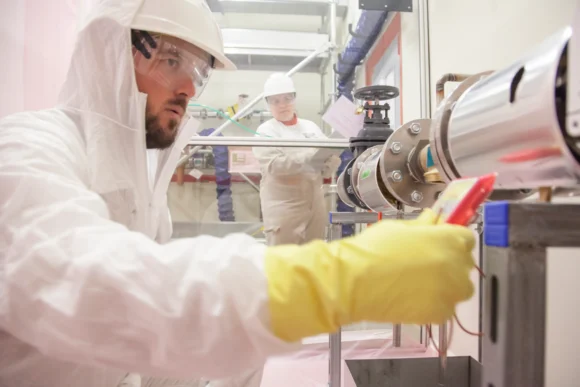 Élèves ingénieurs en tenue de protection effectuant un contrôle de maintenance lors d'une formation à l'Institut de Technologie Nucléaire de l'ISTP